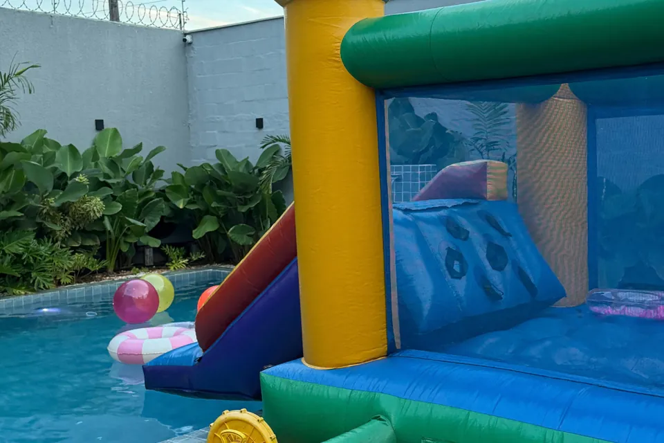 Pula-pula e brinquedo inflável ao lado da piscina aquecida na Piccolini Eventos, em Goiânia