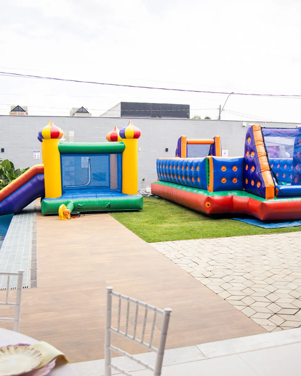 Pula-pula e brinquedos infláveis montados ao lado da piscina na Piccolini