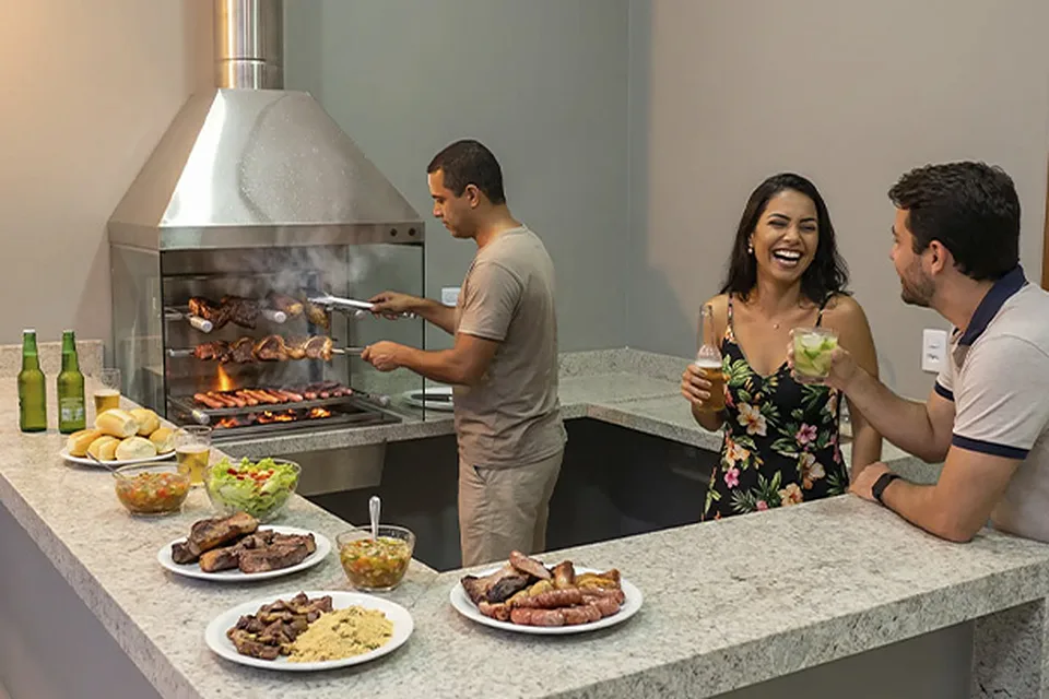 Pessoas fazendo churrasco e conversando na área gourmet da Piccolini Eventos