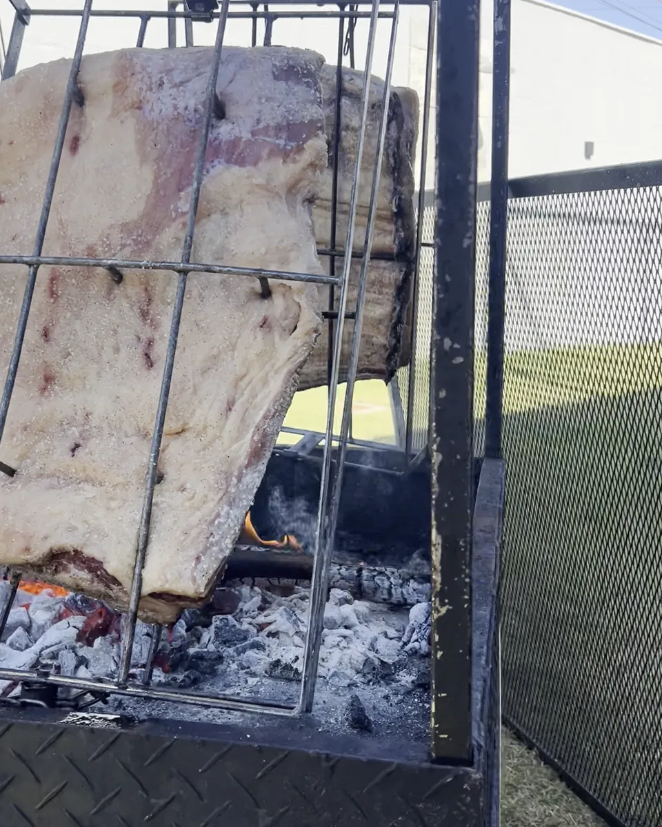 Costela de fogo de chão assando na brasa no gramado da Piccolini Eventos, em Goiânia