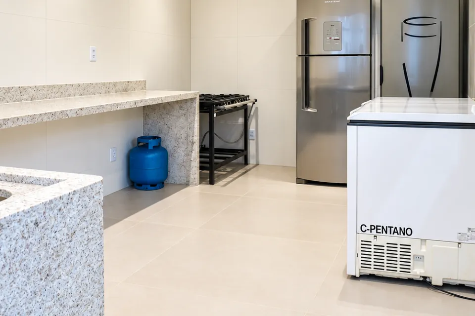 Cozinha da Piccolini Eventos com bancada de granito, geladeira, cervejeira e freezer
