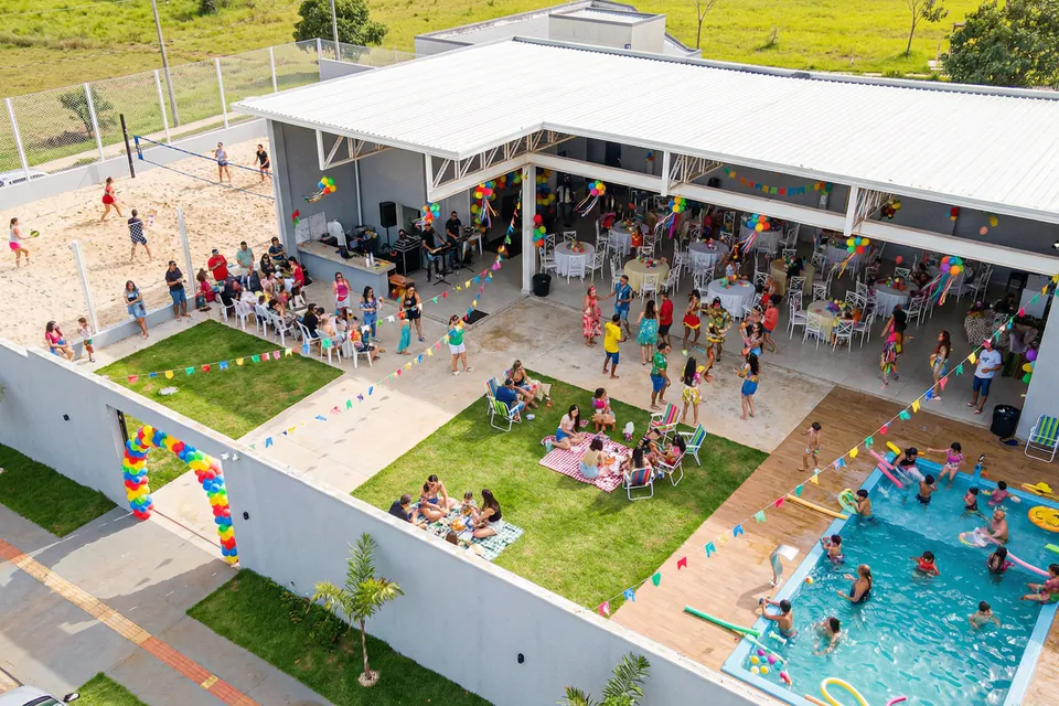 Vista aérea de festa com convidados na piscina e no gramado da Piccolini Eventos, em Goiânia