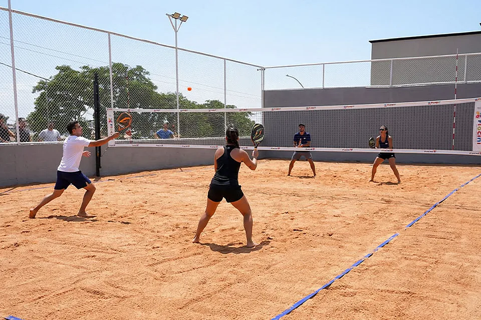Pessoas jogando beach tennis na quadra de areia da Piccolini Eventos, em Goiânia