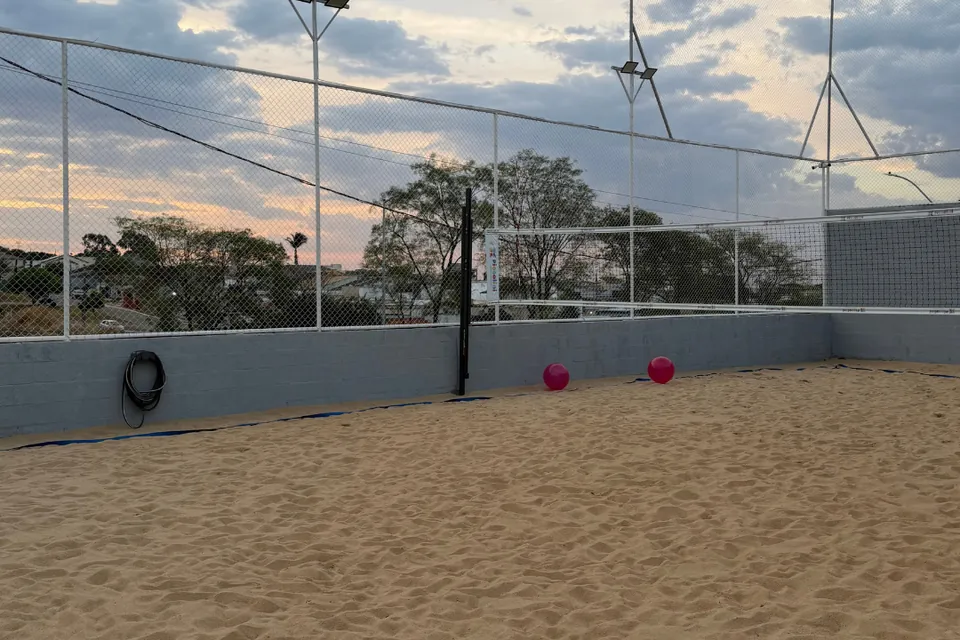 Quadra de areia da Piccolini Eventos ao entardecer, com rede e iluminação, em Goiânia