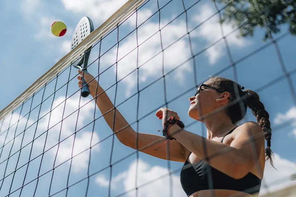 Jogadora de beach tennis na rede da quadra de areia da Piccolini Eventos, em Goiânia